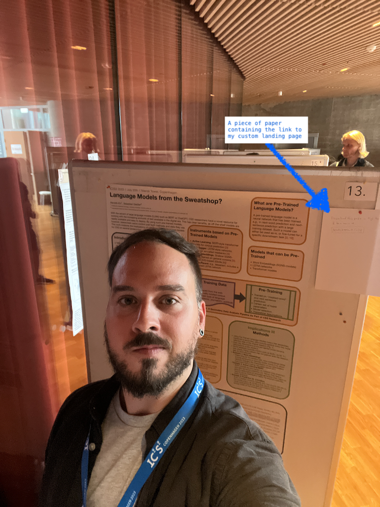A selfie in front of my poster at IC2S2 2023 in Copenhagen where you can see the piece of paper I used to direct people to my custom landing page.